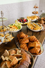 beautiful brunch buffet spread at event including croissants, fresh fruit, crudite and muffins