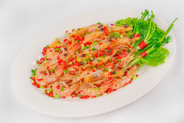A plate of whole steamed shrimp garnished with finely chopped red and green chilies, scallions, and fresh lettuce, served on a white dish.