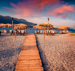 nice summer view of Fokianos beach with wooden pier and straw umbrellas and wooden pier. Calm...