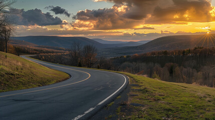 Serene winding road through rolling hills at sunset with dramatic clouds