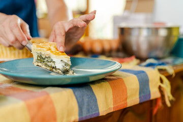 Chef serving slice of chard cake on blue plate