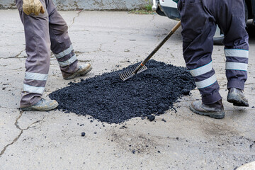men repairing a damaged asphalt street with tar in latin america in bolivia - repair concept