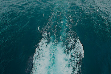 Naklejka premium Stunning aerial view of a boat's wake, turquoise water, white foam. Perfect for travel, adventure, or ocean themes.