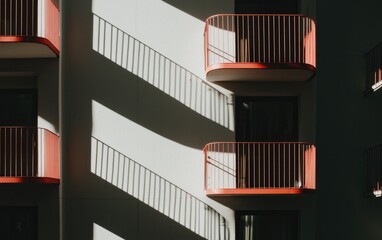 Fototapeta premium Red Balconies And Long Shadows On White Building