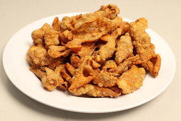 This image shows a plate of crispy, deep-fried pork rinds or chicharrón. Let me know if you need a...