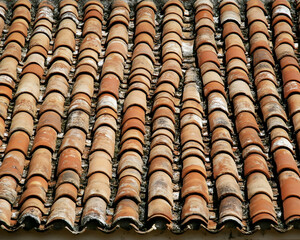 Weathered terracotta roof tiles, close-up texture.  Aged clay roof pattern.