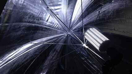 Reflector umbrella studio. Close up of silver reflector umbrella light bulb or photo lamp for...