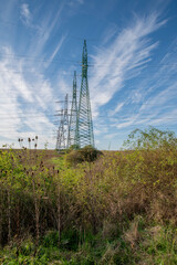 High voltage power lines and power pylons in the agricultural field. Electricity distribution.