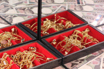 鏡に映る1万円札と金のジュエリー