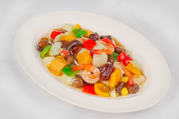 A plate of stir-fried shrimp with assorted vegetables, including bell peppers, mushrooms, onions, and pineapple, in a glossy savory sauce.