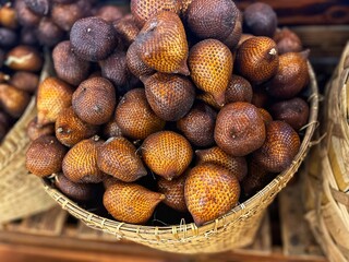 Fresh salak, also known as snake fruit, with scaly reddish-brown skin and juicy white flesh....