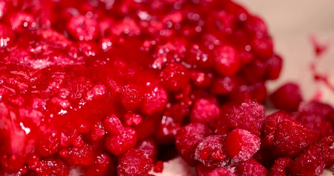 frozen sweet red raspberries for long-term storage, frozen red raspberries during their melting for dessert in winter close up