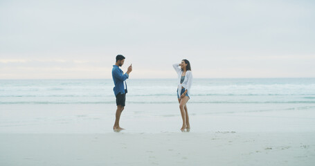 Happy couple, beach and photograph of woman on vacation, holiday or bonding outdoor. People, honeymoon and love by sea for memory, date or space with connection for social media profile picture