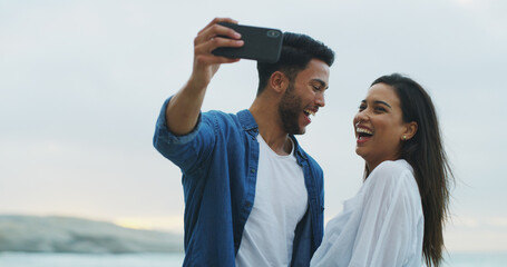 Couple, beach and laugh for selfie with love on honeymoon, holiday or bonding outdoor. Woman, man...
