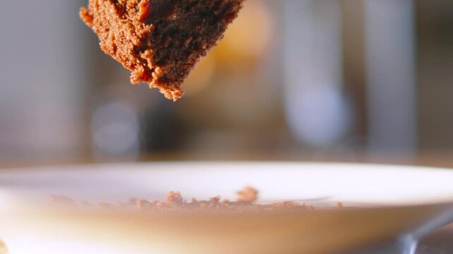 Fork Gently Picking Up Piece of Milk Chocolate Fudge Cake Dessert with Shallow DOF. Eating with Cutlery. Served at Birthday Parties or Afternoon Tea. Food Photography.