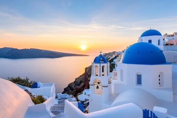 Charming whitewashed church with blue domes overlooking the Aegean Sea at sunset in Oia, Santorini, Greece