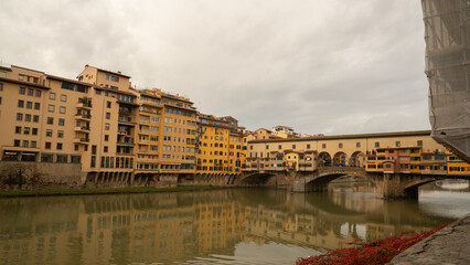 The Ponte Vecchio bridge in Florence, Italy, lined with colorful medieval buildings over the Arno River.