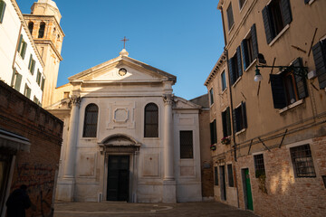 A charming historic church in Venice, Italy, surrounded by old buildings in a quiet square.