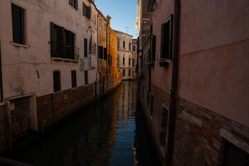 Sunlit Canal with Historic Buildings in Venice, Italy
