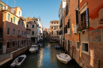 Sunlit Canal with Historic Buildings in Venice, Italy

