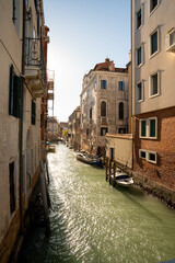 Sunlit Canal with Historic Buildings in Venice, Italy

