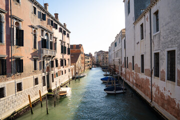 Sunlit Canal with Historic Buildings in Venice, Italy
