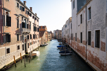 Sunlit Canal with Historic Buildings in Venice, Italy
