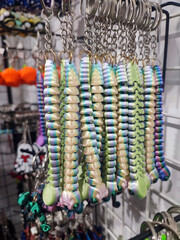Fototapeta premium Objects keychains in form of caterpillar, models of toys printed on 3D printer from multi-colored molten plastic hanging on chain. Concept 3D Printing. Modern 3D Printing additive technology.