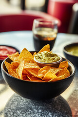 Delicious plain kettle chips on a tabletop, vibrant colours, and tempting dips
