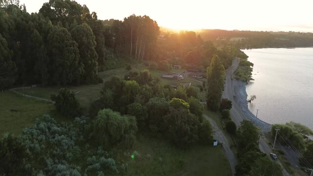 Aerial: Ranco Lake shore near Lago Ranco at sunset with trees and sky in Ranco Province, Los Rios Region, southern Chile, push in pan drone shot
