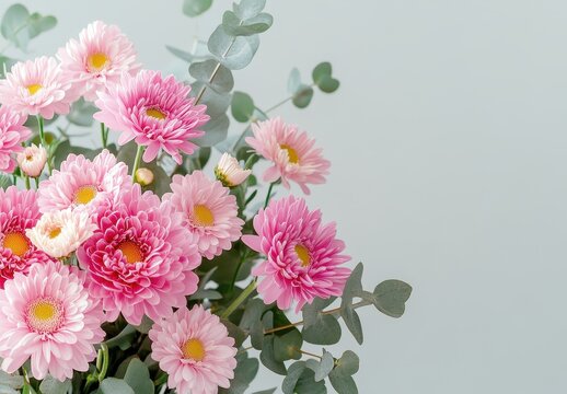 Beautiful arrangement of pink flowers and green eucalyptus leaves on a soft pastel background, perfect for floral design inspiration and spring decor ideas