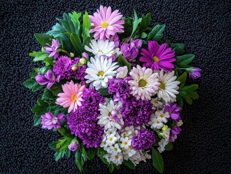Beautiful Arrangement of Purple and Pink Flowers with Green Leaves on a Dark Background for Floral Decor or Nature Inspired Artwork