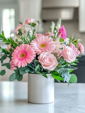 Beautiful Arrangement of Soft Pink Flowers in a Modern White Vase on a Bright Kitchen Table Surrounded by Natural Light