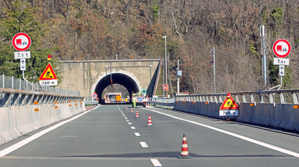 tunnel on dual carriageway road and traffic cones to delimit roadworks and safety signs