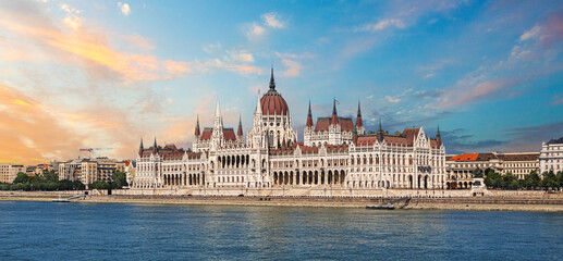 Naklejka premium Hungarian parliament building reflecting on danube river at sunset in budapest