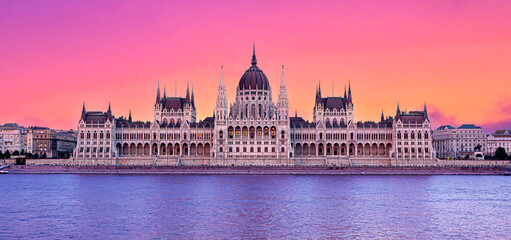 Fototapeta premium Hungarian parliament building reflecting on danube river at sunset with colorful sky