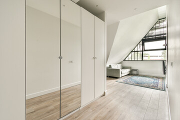 A stylish interior featuring sleek cabinets, elegant furniture, and a vibrant rug in a well-lit room with modern architectural elements.