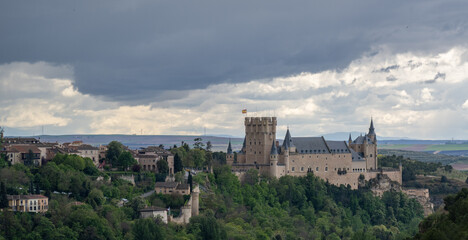 Obraz premium Aerial view of the alcazar of Segovia, Spain, with a stormy cloudy sky.