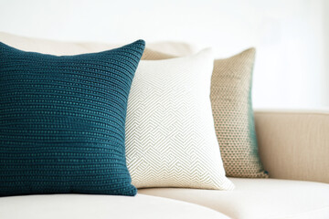 Teal, beige and ivory throw pillows resting on sofa