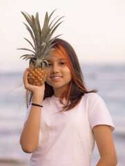 Close up portrait of girl holding pineapple in front of her face. Tropical fruit concept. Smiling face. Lifestyle. Bali.