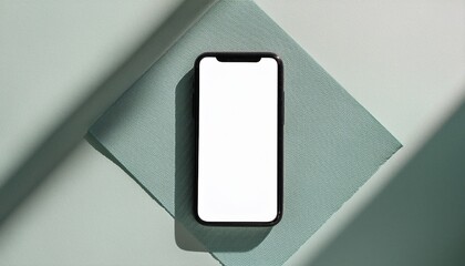 a smartphone with a blank screen on a blue cloth, top view, casting a shadow