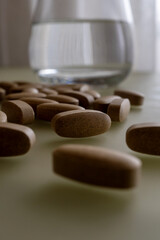 A glass of water and tablets on the table. Lifestyle. Close-up