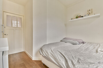 A serene bedroom showcasing a comfortable bed with soft linens, minimalist decor, and a warm light color palette, perfect for relaxation and rest.