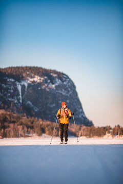 Woman XC-skis in front of Mount Kineo in winter, Maine