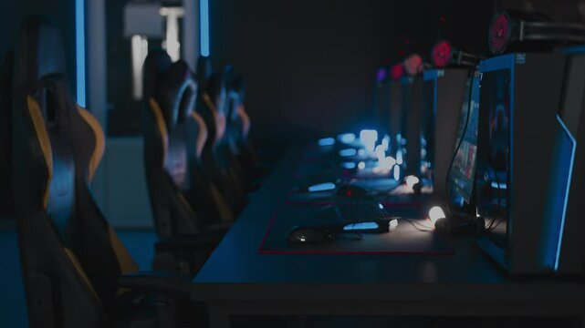 Modern cyber computer club for videogames and E-sport tournament. Gaming armchairs, mouses and keyboards with RGB lighting animation, mats. LAN cafe. No one, nobody. Handheld shot