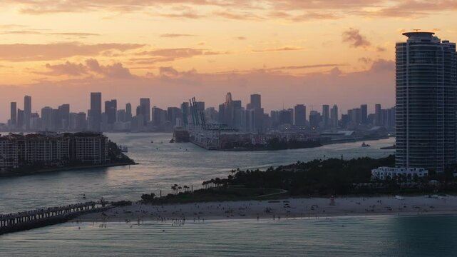 Enjoy a breathtaking aerial view of South Pointe Pier and Fisher Island during a stunning sunset, highlighting the enchanting beauty of Miami Beach, Florida