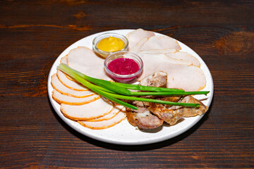 Delicious sliced meats served with sauces and green onions