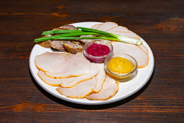 Delicious platter of sliced meats with sauces and green onions