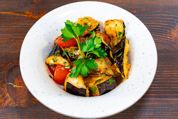 Delicious vegetable dish with eggplant and herbs served in bowl