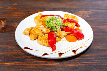 Delicious sweet and sour chicken with bell peppers on a plate